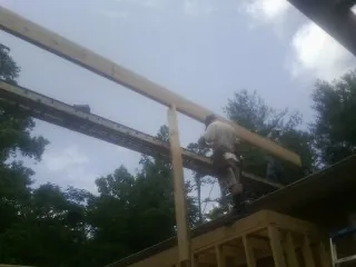 Carpenter setting a ridge beam over a new addition frame — Ice Dam Removal by Roofing Brothers in Canaan