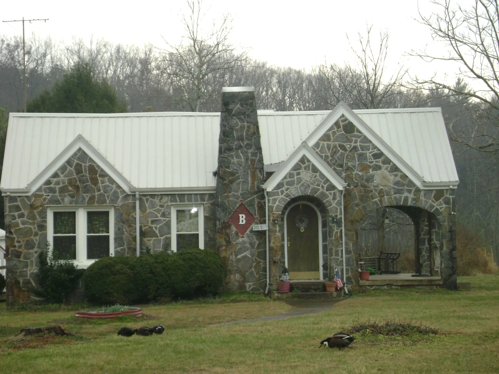 White metal roof on a stone cottage with steep gables in Canaan